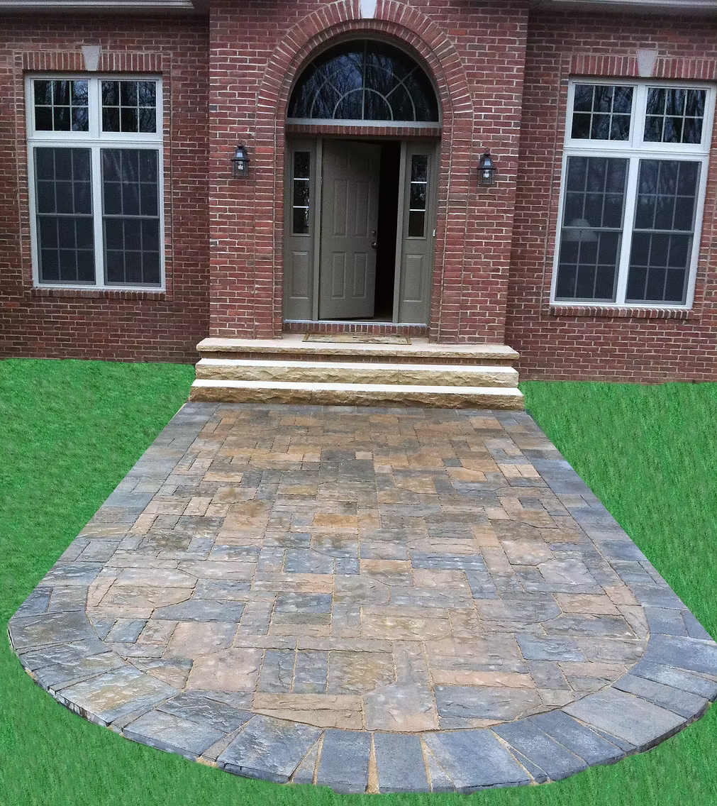 Stamped concrete front walkway leading to a brick colonial home