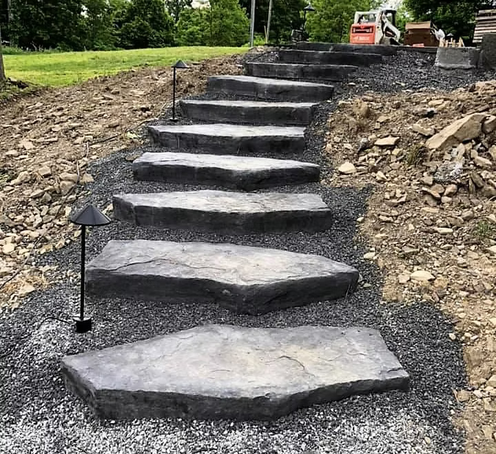 Large natural-look stamped concrete steps cut into a hillside