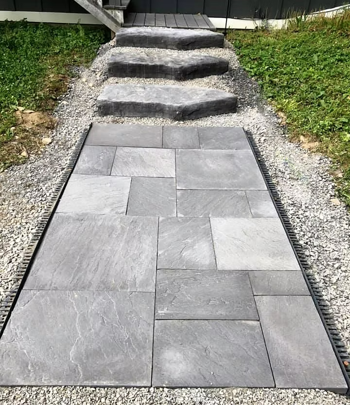 Large format slate pavers leading to natural stone steps