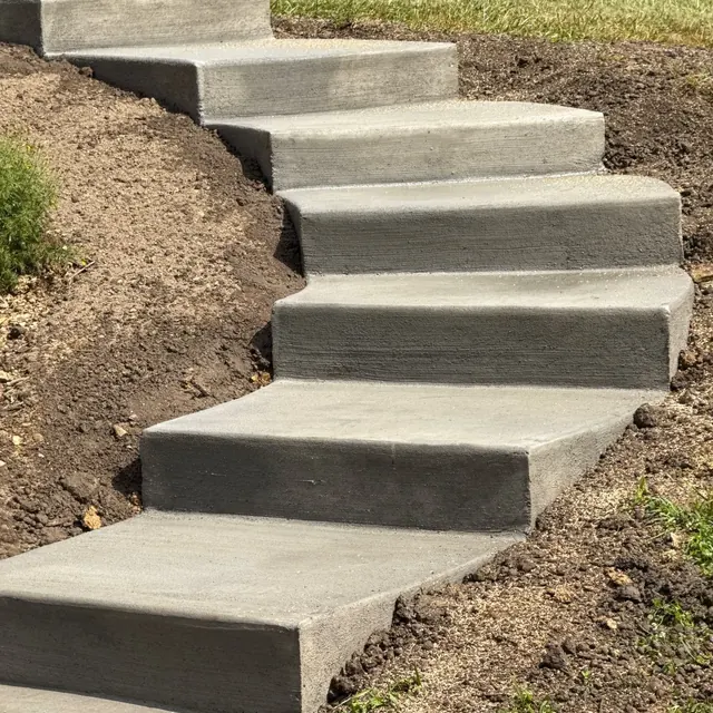 Curved broom-finished concrete landscape steps leading through a residential yard
