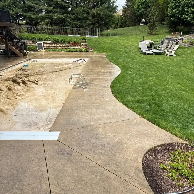 Curved stamped concrete pool deck with a custom border and slate pattern