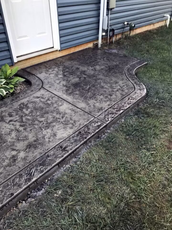 Charcoal stamped ashlar patio with curved decorative border edge